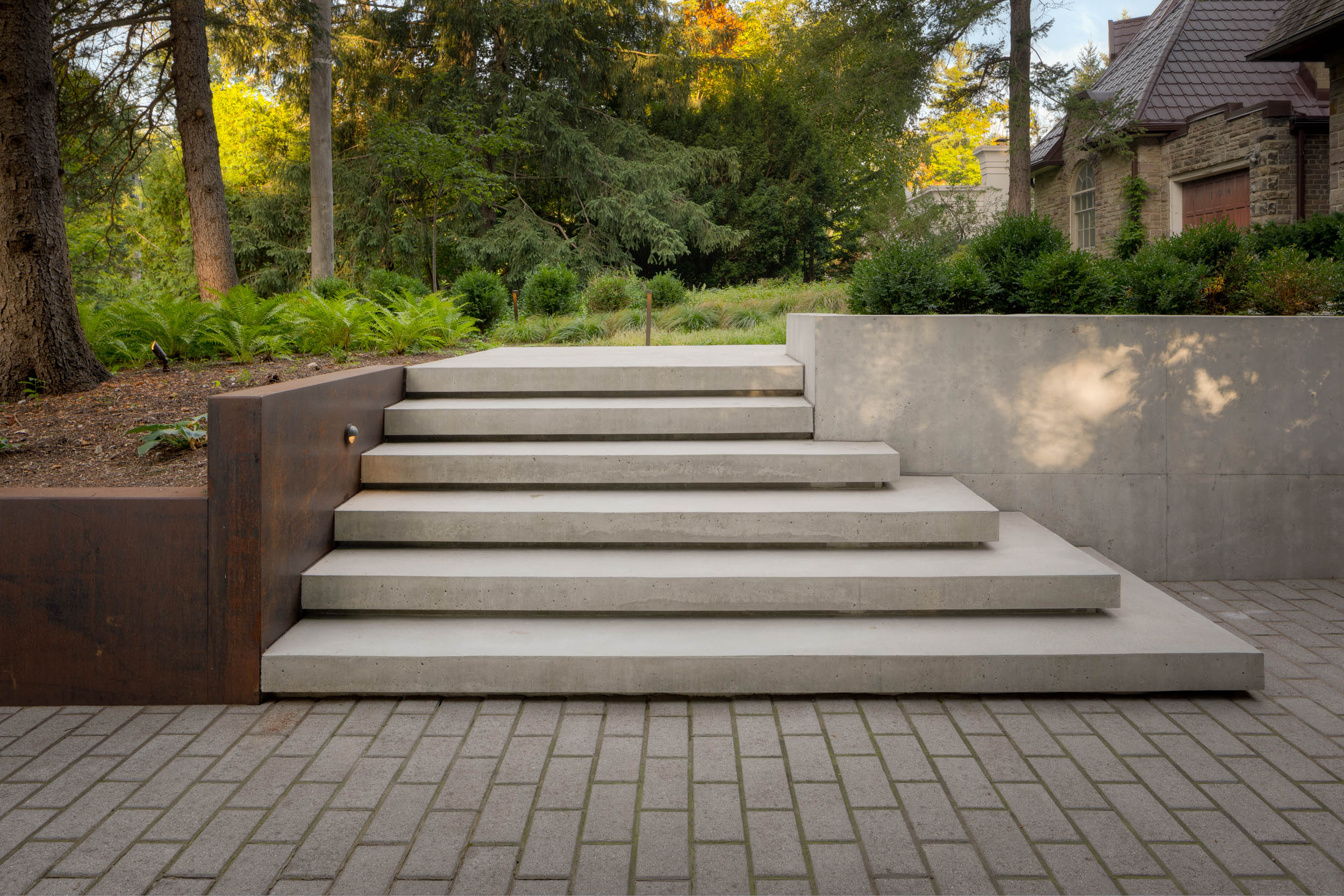 Modern floating concrete steps leading to driveway. 