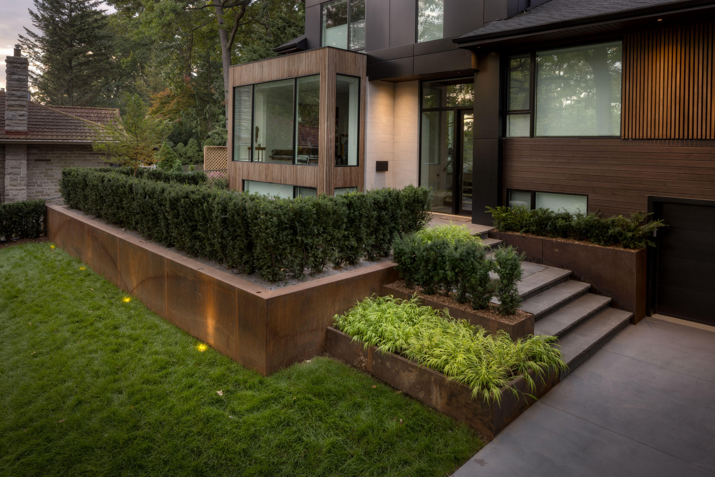 Modern residential entrance with corten steel planters and steps. 